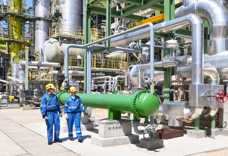 group of industrial workers in a refinery - oil processing equip